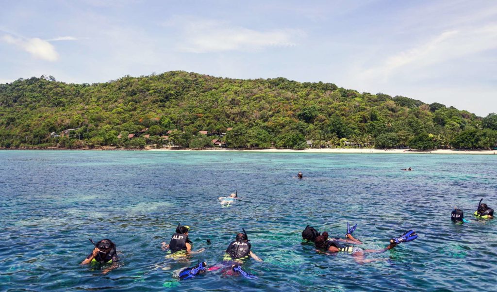 Picture taken above water of people snorkeling near Phuket